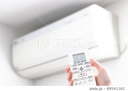 エアコンのリモコンを操作する女性の手 エアコンのリモコンを操作する女性の手 89541162