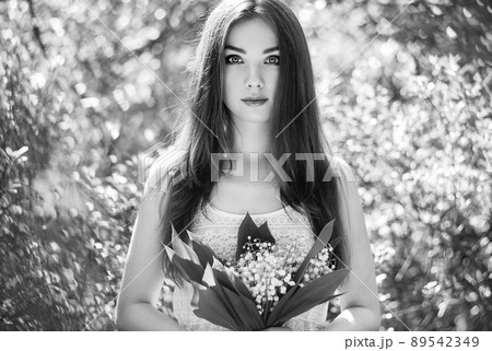 Portrait of beautiful young woman with lily of the valley 89542349