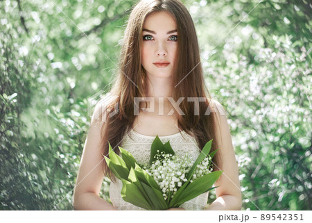 Portrait of beautiful young woman with lily of the valley 89542351