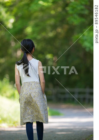 真夏の公園で遊んでいる可愛い小学生の女の子の姿 89546182