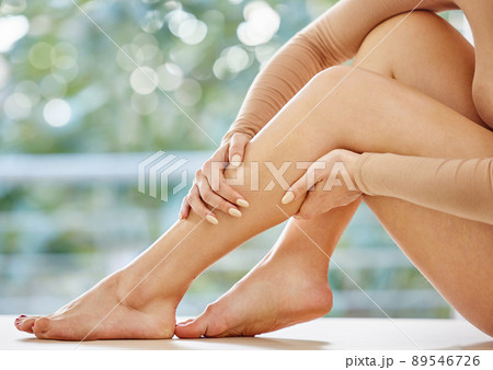 I love my legs silky smooth. Cropped shot of an unrecognizable woman feeling her legs in the bathroom. 89546726