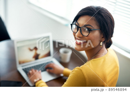 Getting the job done. Cropped shot of an attractive young woman sitting alone in her home and using her laptop. 89546894
