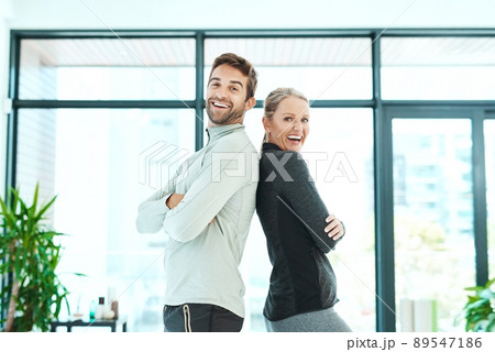 We work together. Cropped shot of two people standing together in a fitness center. We work together. Cropped shot of two people standing together in a fitness center. 89547186