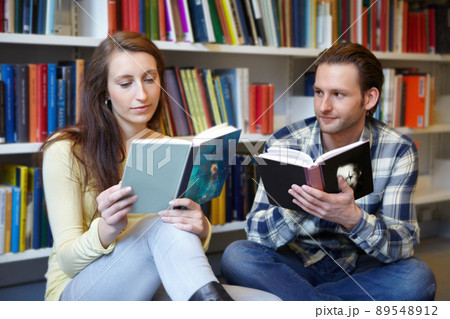 Her intelligence is mesmerizing. Shot of a young man and woman bonding over their love for books. Her intelligence is mesmerizing. Shot of a young man and woman bonding over their love for books. 89548912