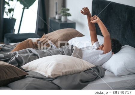 A boy laying in bed and a dog together with him A boy laying in bed and a dog together with him 89549717