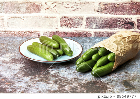 Healthy organic baby cucumbers in a plate and a paper bag. Healthy snack food Healthy organic baby cucumbers in a plate and a paper bag. Healthy snack food 89549777