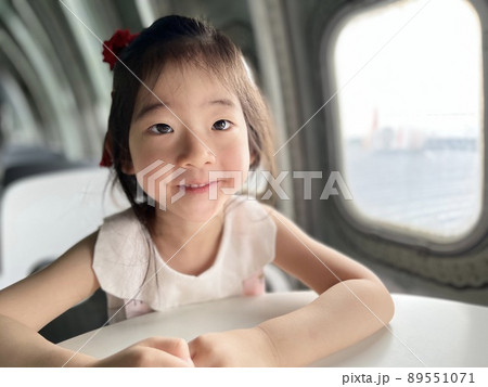 Beautiful little girl smiles on the table with white space background 89551071