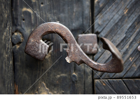 Ornamental vintage iron door handle on wooden door Ornamental vintage iron door handle on wooden door 89551653