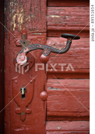 Ornamental vintage iron door handle on wooden door 89551654