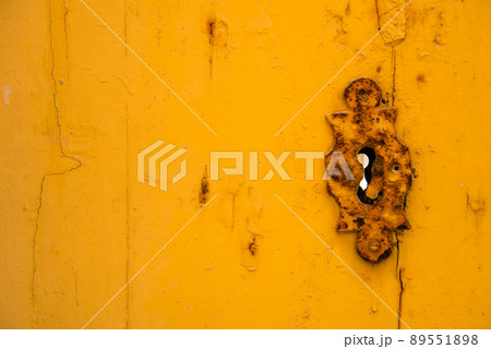 Rusty vintage keyhole on a yellow door Rusty vintage keyhole on a yellow door 89551898