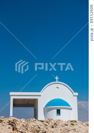 Traditional white chapel with a blue roof on the seaside. Agioi Anargyroi, Cyprus 89552606