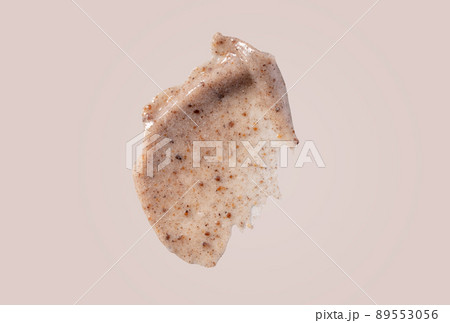 Scrub smear swatch isolated on beige background. Peeling cream smudge with exfoliating particles. Cosmetic skincare product with abrasive particle sample, gentle nude scrub texture. 89553056