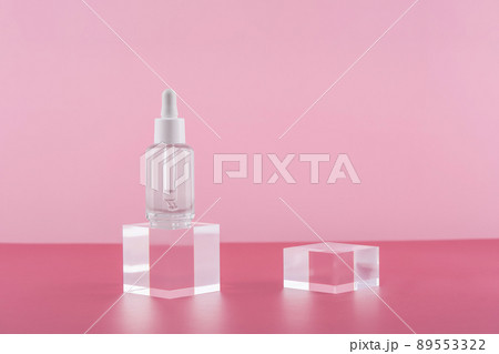 Serum cosmetic bottle with peptides and retinol on acrylic blocks on pink background. Cosmetics transparent product packaging with stylish props. Serum dropper mockup on pedestal podium 89553322