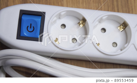 White extension cord with sockets and blue power button. 89553459