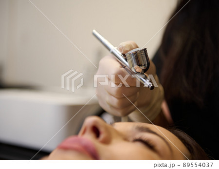 Close-up woman receiving an effective beauty procedure for removing dead skin cells, dermabrasion, gas-liquid peeling during a visit to a beauty salon Close-up woman receiving an effective beauty procedure for removing dead skin cells, dermabrasion, gas-liquid peeling during a visit to a beauty salon 89554037