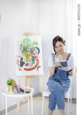 Female artist painting on canvas, Artist studio interior, Draw with watercolor, Drawing supplies , Painting and creativity, Use a brush to draw a pattern by stripes, Artwork, Using Paint Brush. 89554135