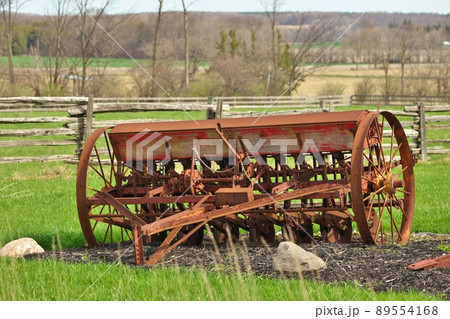 Antique Vintage Farm Seeder Rusty Farm Implement in Field Antique Vintage Farm Seeder Rusty Farm Implement in Field 89554168