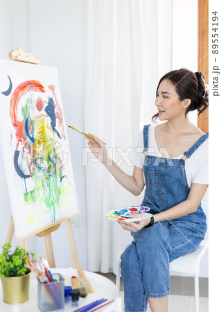 Female artist painting on canvas, Artist studio interior, Draw with watercolor, Drawing supplies , Painting and creativity, Use a brush to draw a pattern by stripes, Artwork, Using Paint Brush. 89554194