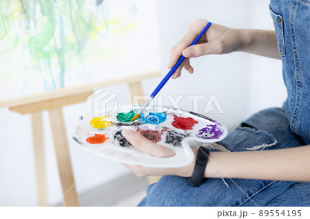 Female artist painting on canvas, Artist studio interior, Draw with watercolor, Drawing supplies , Painting and creativity, Use a brush to draw a pattern by stripes, Artwork, Using Paint Brush. 89554195