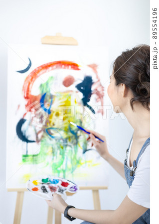 Female artist painting on canvas, Artist studio interior, Draw with watercolor, Drawing supplies , Painting and creativity, Use a brush to draw a pattern by stripes, Artwork, Using Paint Brush. 89554196