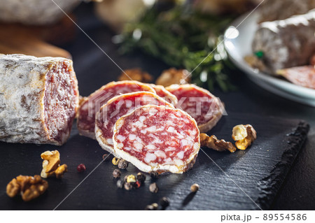 Traditional sausage with white mold. Dried sliced pork salami on cutting board. Traditional sausage with white mold. Dried sliced pork salami on cutting board. 89554586