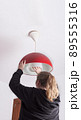 unrecognizable blonde woman changing a light bulb at home, DIY. 89555316