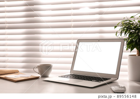 Laptop on desk near window in office. Comfortable workplace 89556148