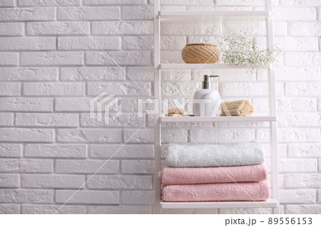 Clean towels on shelving unit in bathroom. Space for text Clean towels on shelving unit in bathroom. Space for text 89556153
