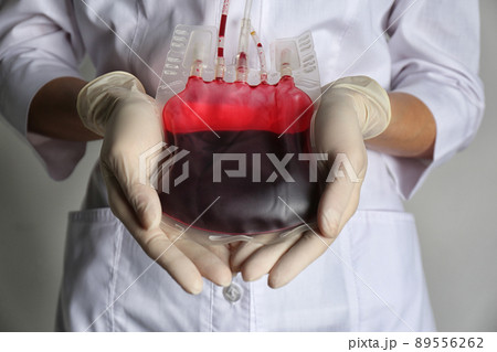 Woman holding blood for transfusion on light grey background, closeup. Donation concept 89556262