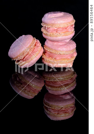 Three pink macarons on glossy black background Three pink macarons on glossy black background 89556464