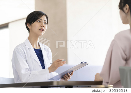 相手の話を聞く白衣を着た女性　女性医師・医療従事者イメージ 89556513