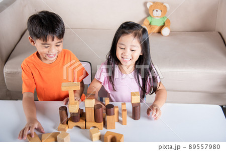 Children boy and girl playing with constructor wooden block building 89557980