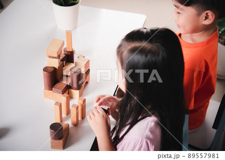 Children boy and girl playing with constructor wooden block building 89557981