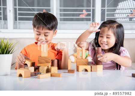 Children boy and girl playing with constructor wooden block building 89557982
