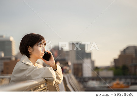 屋外で通話する女性 89558636