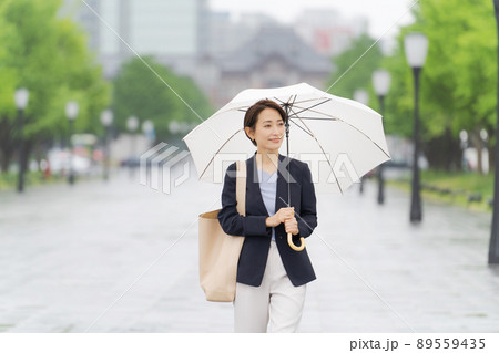 傘を持って歩く女性 89559435