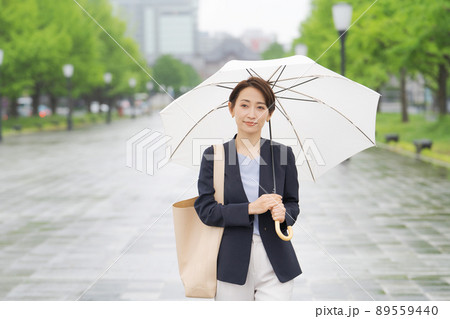 傘を持って歩く女性 傘を持って歩く女性 89559440