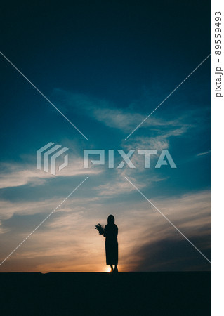 女性のシルエットと美しい夕焼け空 女性のシルエットと美しい夕焼け空 89559493