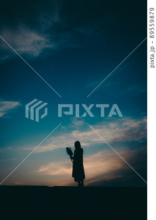 女性のシルエットと美しい夕焼け空 89559879