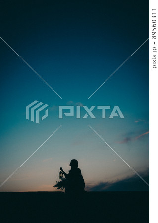 女性のシルエットと美しい夕焼け空 女性のシルエットと美しい夕焼け空 89560311