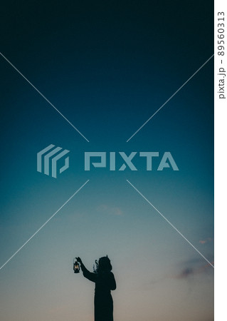 女性のシルエットと美しい夕焼け空 89560313