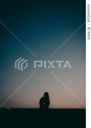 女性のシルエットと美しい夕焼け空 89560404