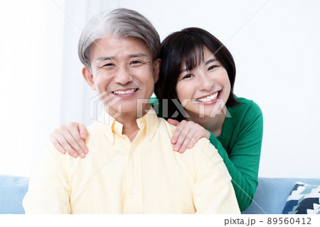 リビングでくつろぐミドルの父と若い娘の親子 89560412