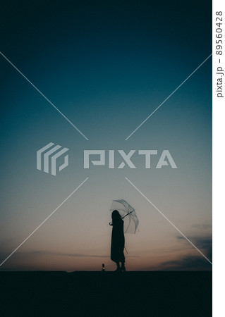 女性のシルエットと美しい夕焼け空 女性のシルエットと美しい夕焼け空 89560428