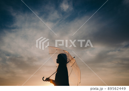 女性のシルエットと美しい夕焼け空 89562449