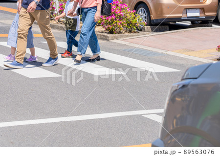 一時停止する車の前で横断する歩行者家族 89563076
