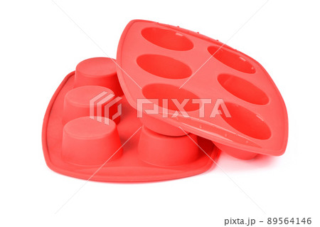 Red silicone form for cooking muffin and cupcake on white background. Side view. High resolution photo. 89564146