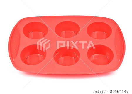 Red silicone form for cooking muffin and cupcake on white background. Side view. High resolution photo. Red silicone form for cooking muffin and cupcake on white background. Side view. High resolution photo. 89564147