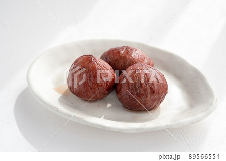 白い皿に乗った3つの栗の渋皮煮 89566554