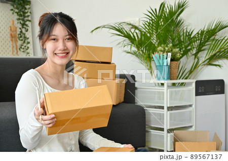 Female online shop owner packing her stuff in the living room 89567137
